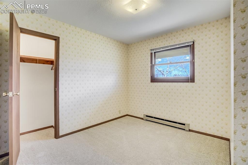 Image 23 of 43: Bedroom #1 with closet and shelving behind the door