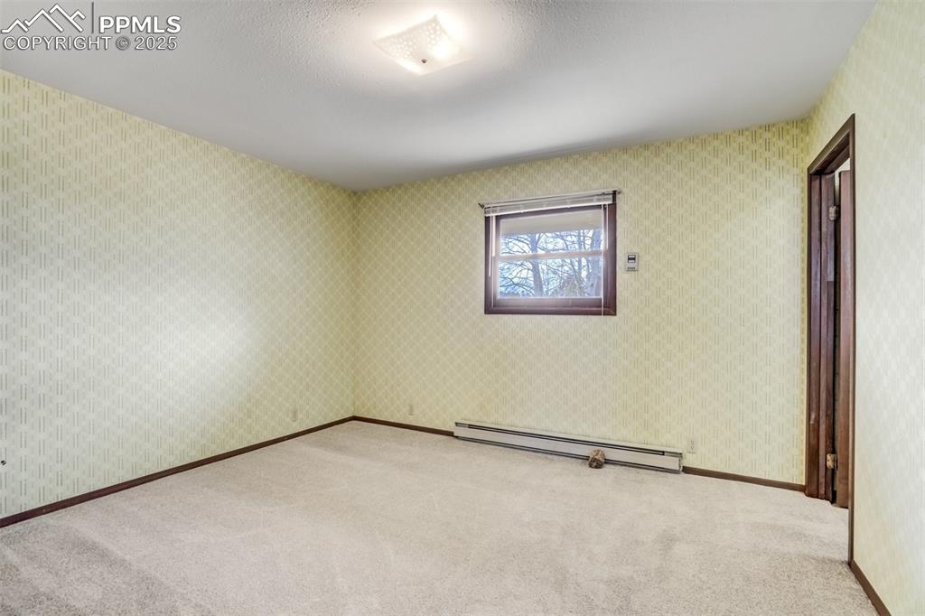 Image 25 of 43: Large primary bedroom with closet and attached 3/4 bath.