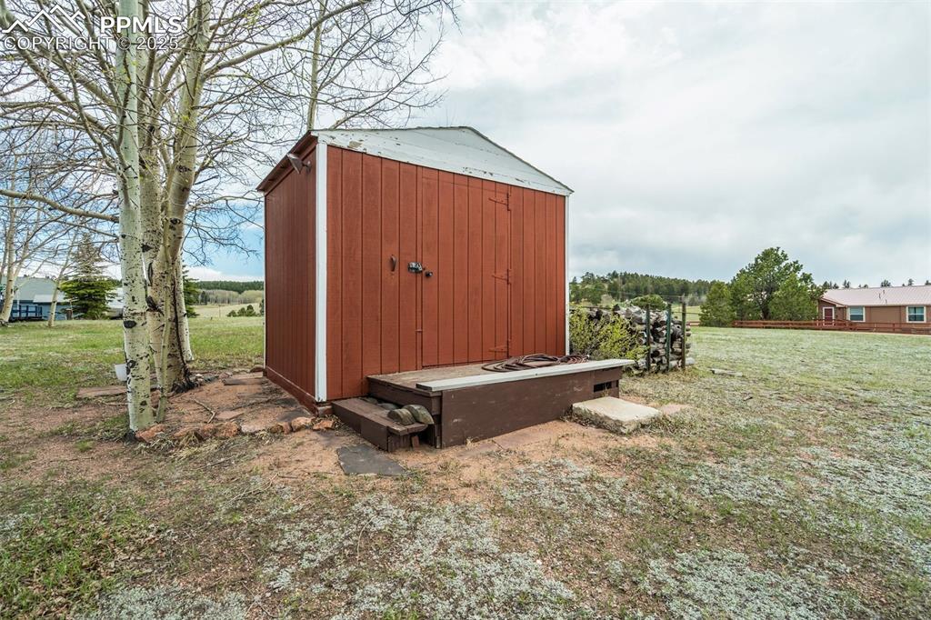 Image 29 of 43: Extra storage and a pile of firewood ready for cooler weather of campfires