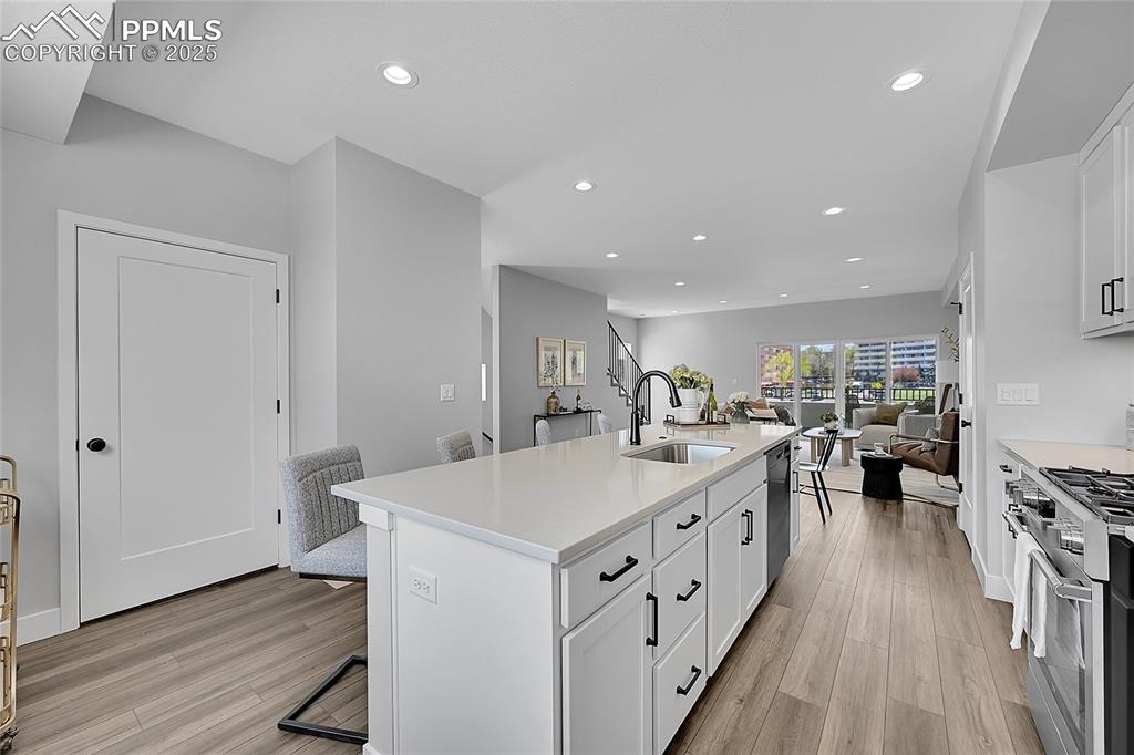Image 11 of 31: Kitchen with light wood-style flooring, recessed lighting, appliances with