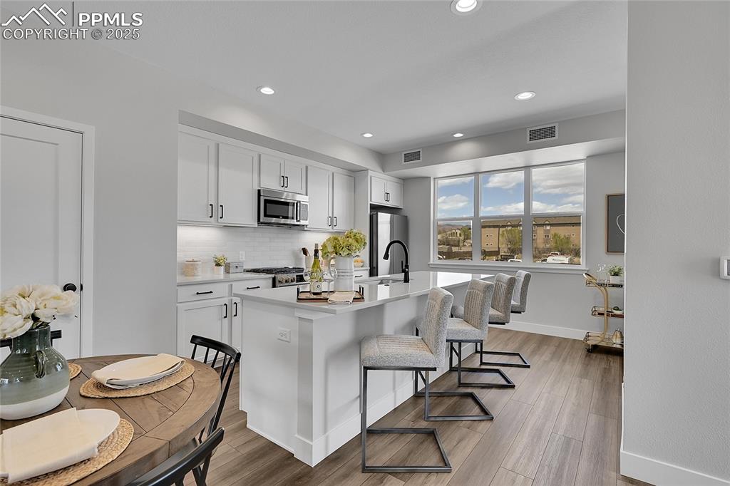 Image 12 of 31: Kitchen featuring tasteful backsplash, appliances with stainless steel fini