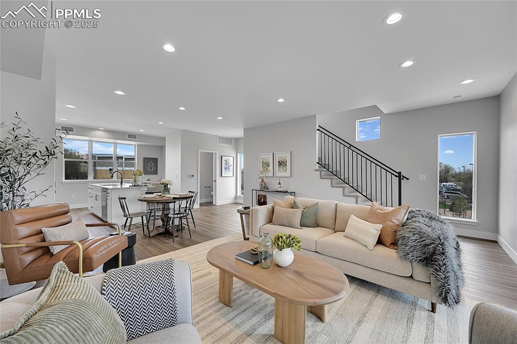 Image 16 of 31: Living area featuring recessed lighting, stairs, and light wood-type floori
