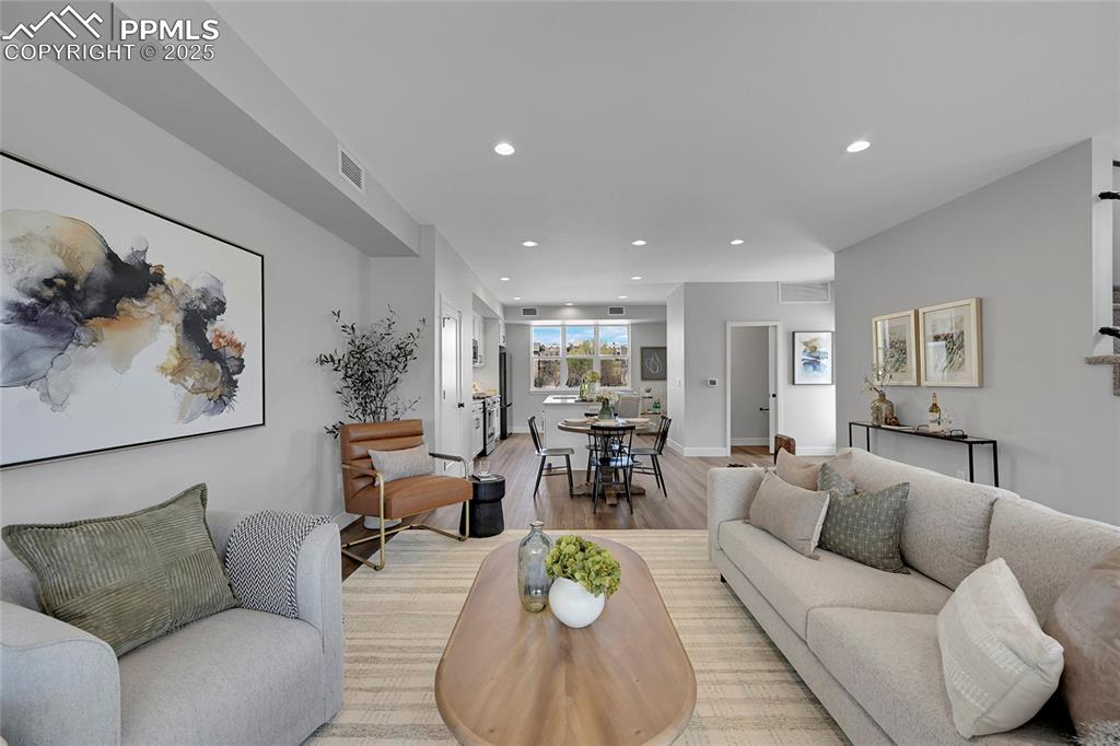 Image 17 of 31: Living room featuring baseboards, visible vents, light wood-style flooring,