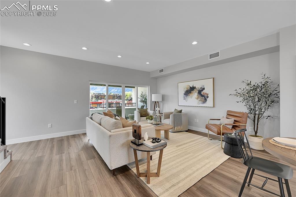 Image 18 of 31: Living area with baseboards, visible vents, light wood-style floors, and re