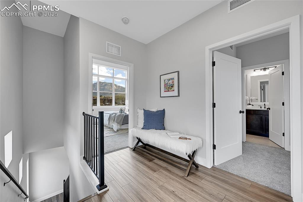 Image 21 of 31: Living area with an upstairs landing, and light wood-style floors