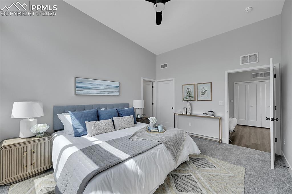 Image 25 of 31: Bedroom with high vaulted ceiling and carpet