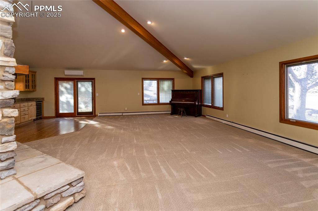 Image 6 of 50: Large family room with beamed ceilings