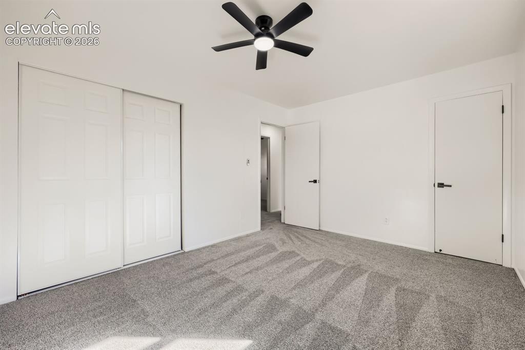 Image 11 of 22: White walls with grey patterned carpeting