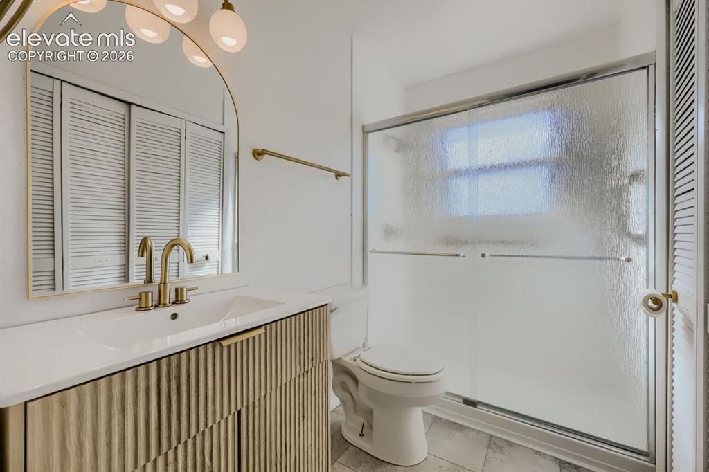 Image 18 of 22: Spa-inspired primary bathroom featuring a floating vanity with brass hardwa