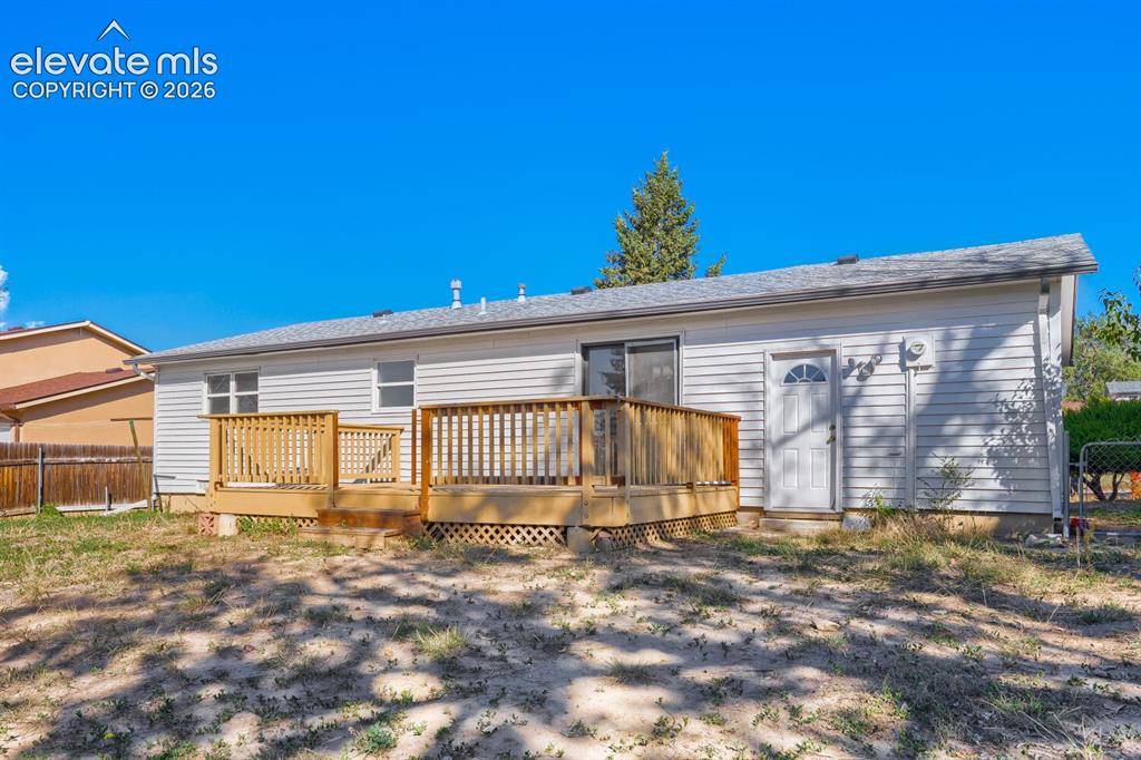 Image 19 of 22: Charming single-story home featuring a spacious wooden deck with railings, 