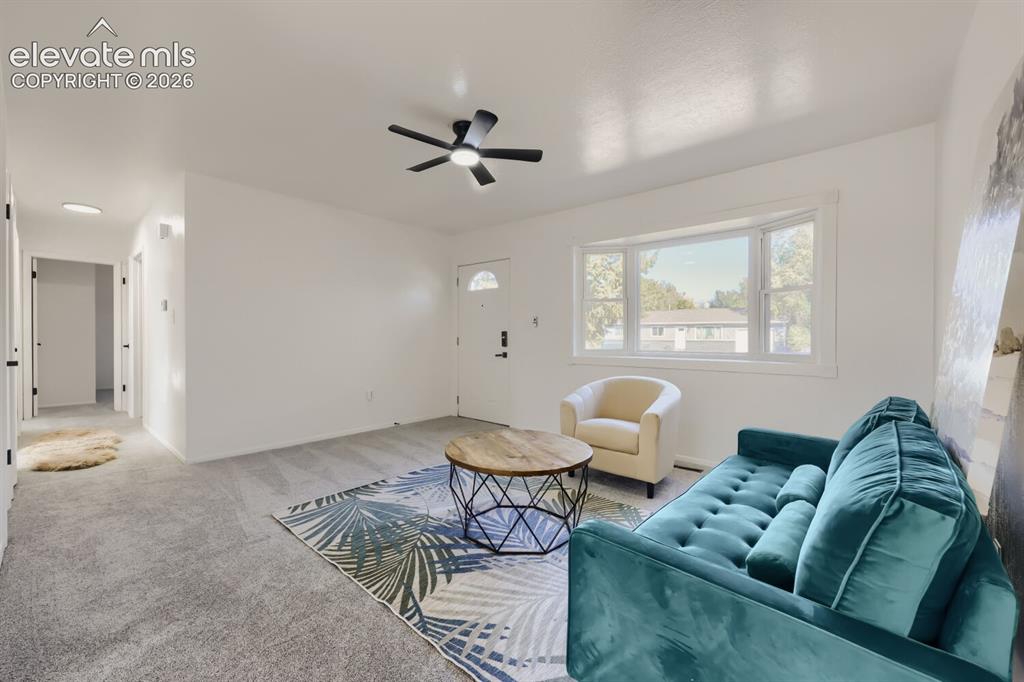 Image 5 of 22: Recessed lighting, bay window, ceiling fan, white paneled doors, and carpet