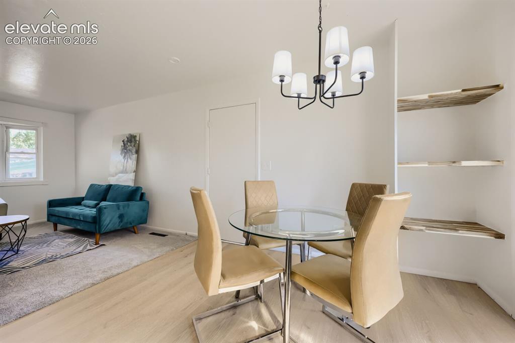 Image 6 of 22: Open-concept living space with wood-finish flooring, a contemporary five-li
