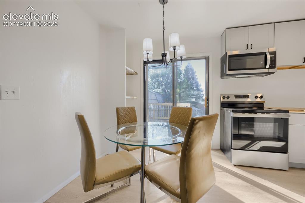 Image 7 of 22: Stainless steel range and microwave, light wood-finish flooring, and white 