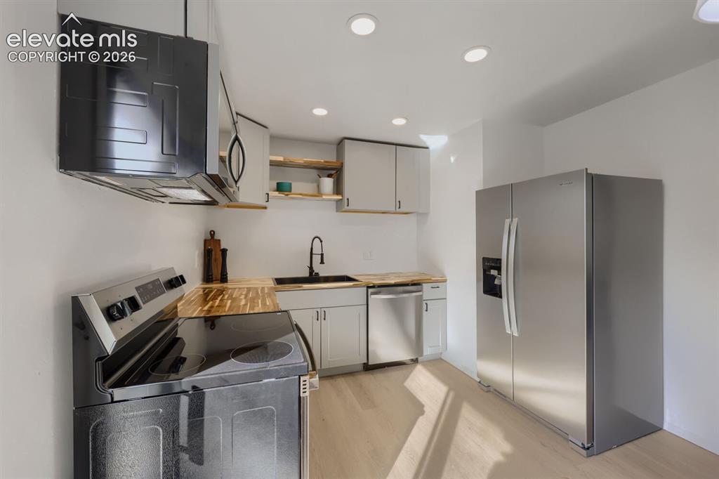 Image 9 of 22: Kitchen featuring wood-finish countertops, stainless steel appliances, rece