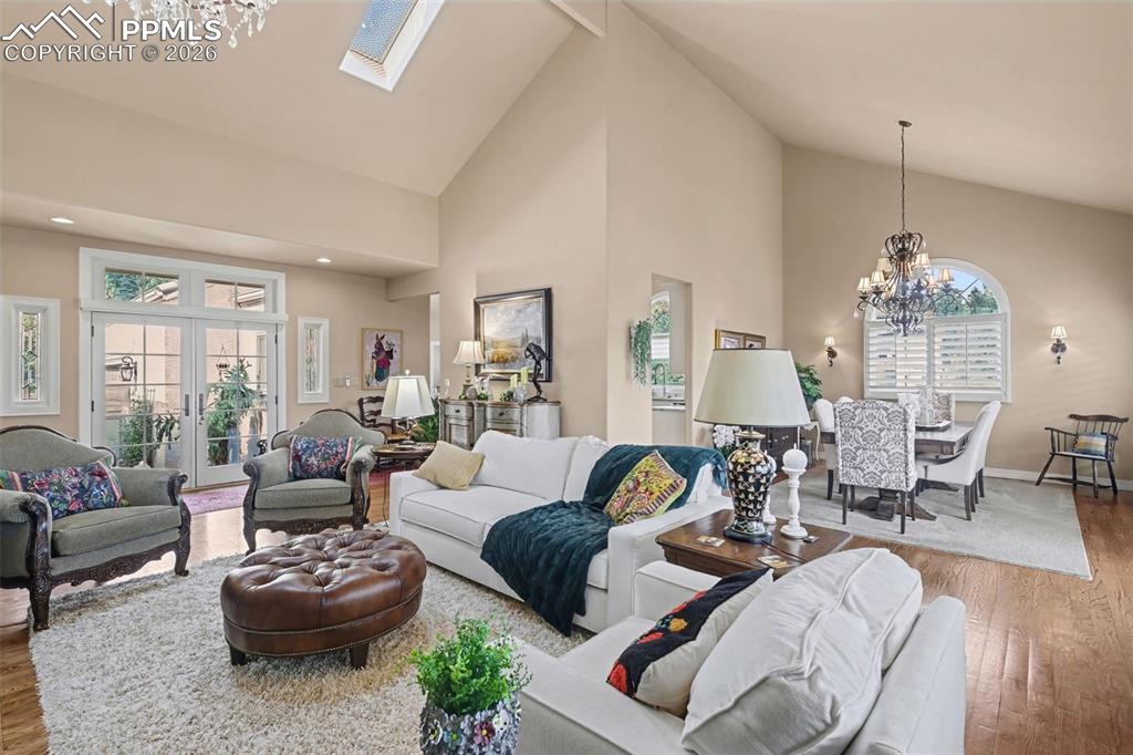 Image 13 of 50: Soaring ceilings and wood floors highlight this expansive open living area.