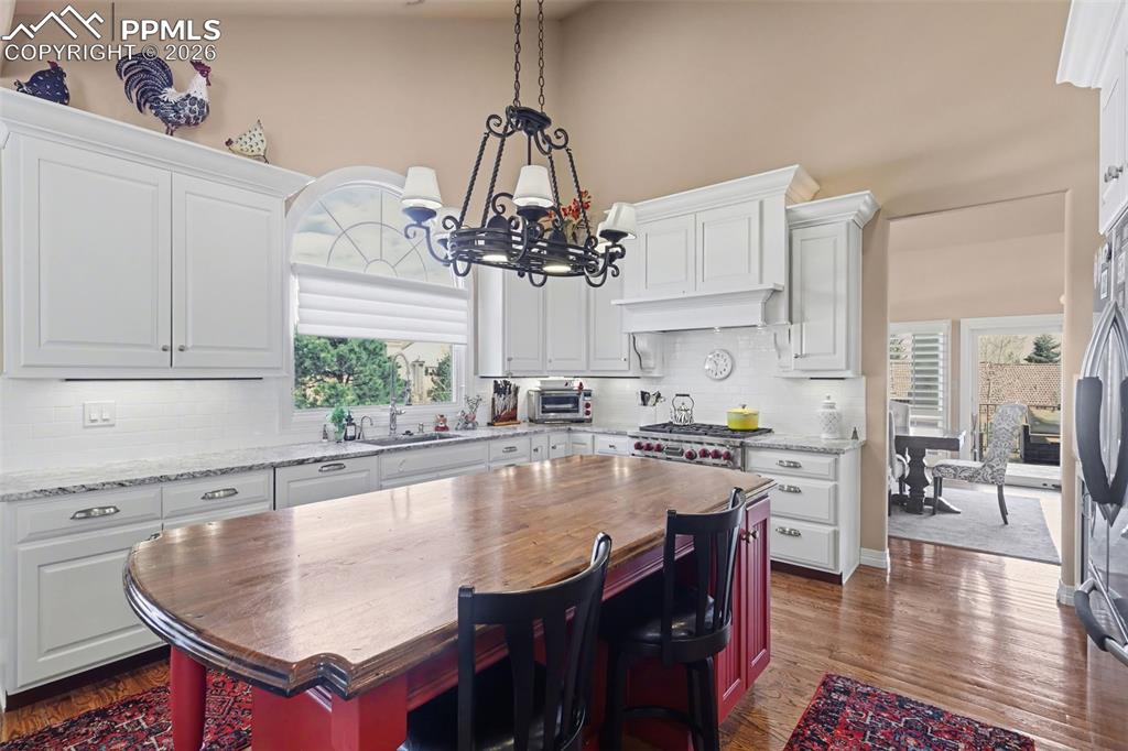 Image 16 of 50: Soaring ceilings and wood floors highlight this expansive open living area.