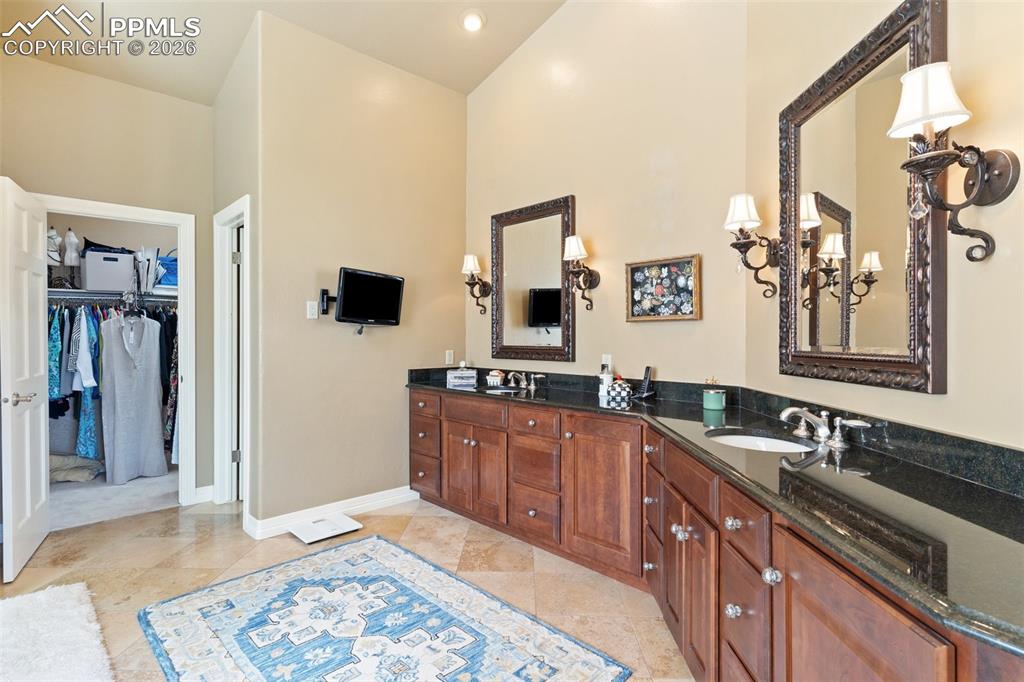 Image 34 of 50: This spacious primary bath features an oversized walk-in closet, double sin