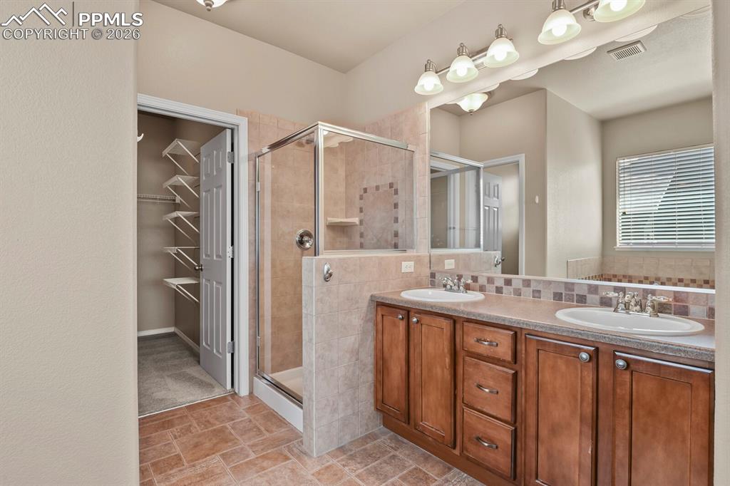 Image 18 of 42: 5-piece primary bathroom followed by a large closet