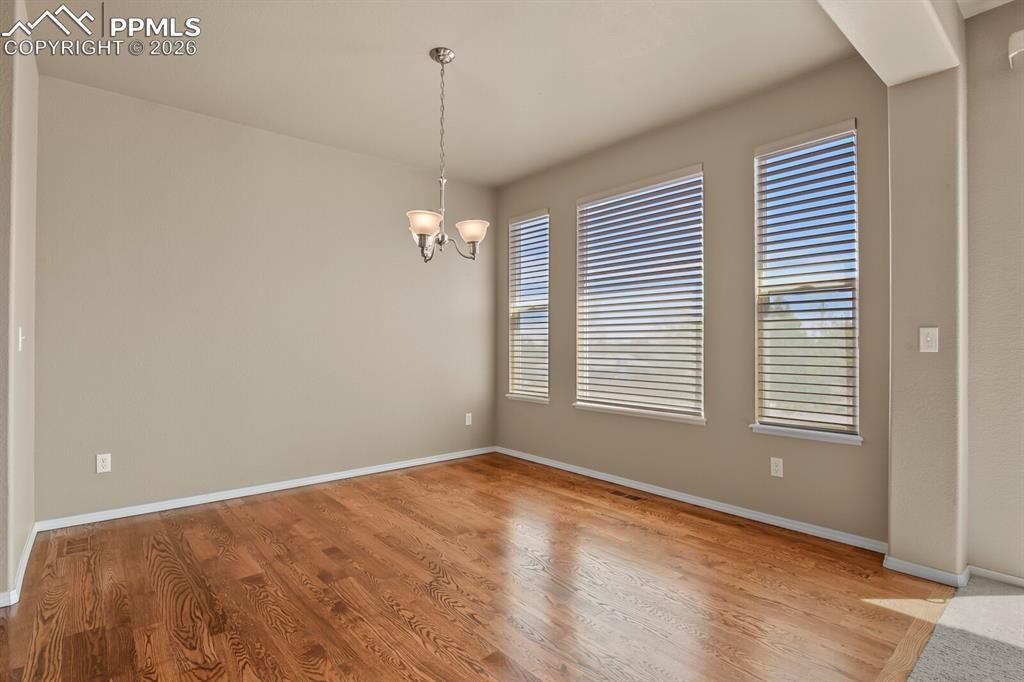 Image 9 of 42: Dining area with beautiful hardwood floors and 3D blinds