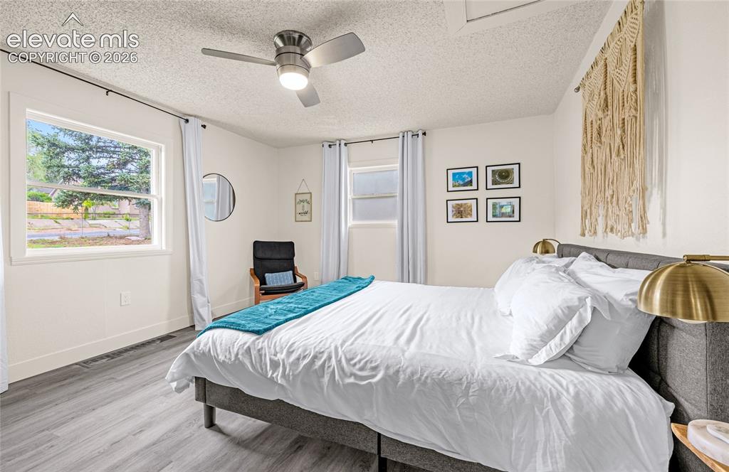 Image 27 of 46: Neutral wall paint, ceiling fan with integrated lighting, wood-finish floor