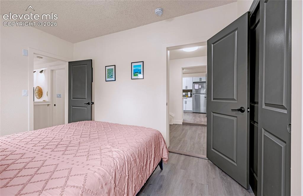 Image 30 of 46: Gray panel doors with matte black hardware, light wood-finish flooring, and
