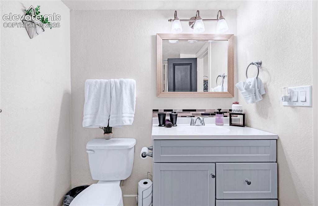 Image 32 of 46: Efficiently designed bathroom featuring a gray vanity with ample storage an