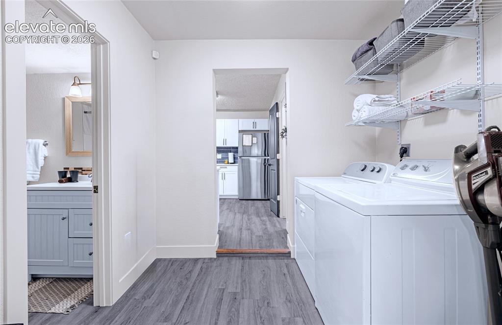 Image 37 of 46: Utility area with wood-finish flooring, white walls, and built-in shelving