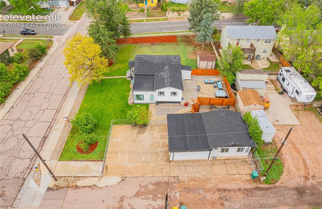 Image 41 of 46: Expansive paved driveway, separate outbuilding, manicured front lawn, and f