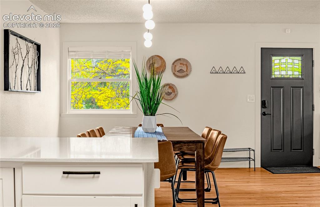 Image 6 of 46: Hardwood flooring, white kitchen island with modern hardware, window with n