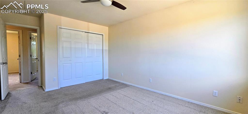 Image 10 of 24: Unfurnished bedroom with carpet flooring, a closet, and ceiling fan