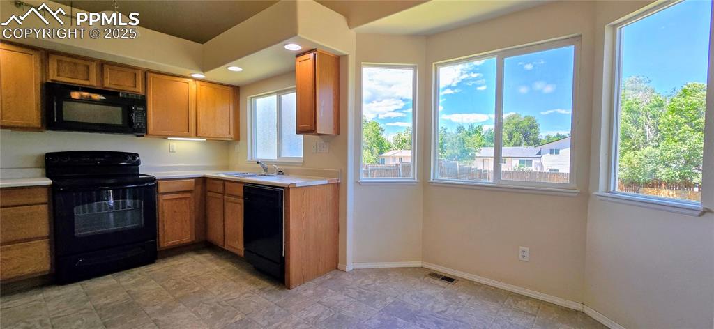 Image 5 of 24: Kitchen featuring black appliances, light countertops, and recessed lightin