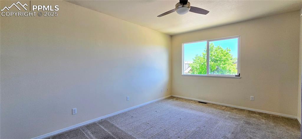 Image 9 of 24: Carpeted spare room featuring baseboards and ceiling fan