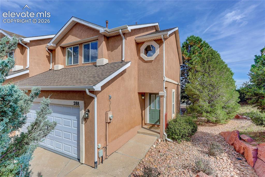 Caption: End unit. Entry to two car garage and front door from Pecan Garden View.