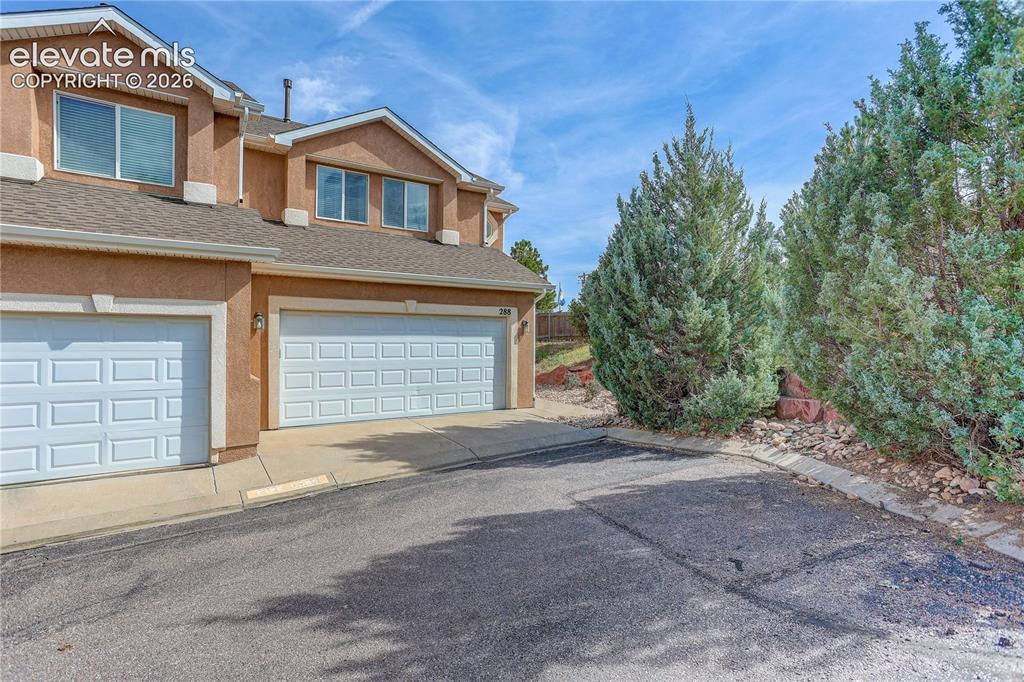 Image 33 of 35: End unit offers private side yard. Entry to garage and front door from Peca