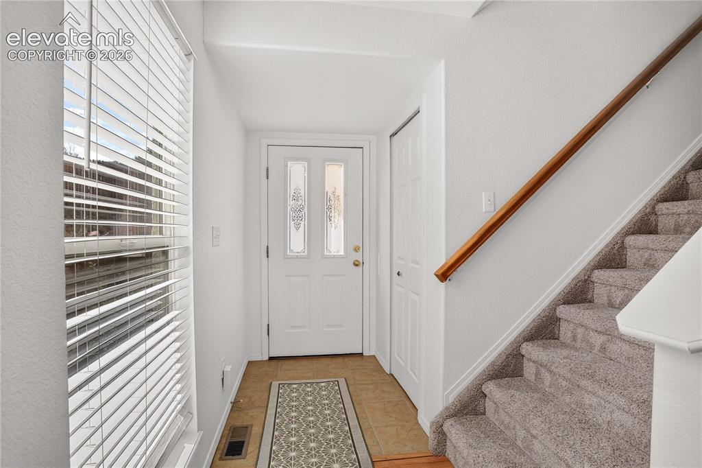 Image 7 of 35: Front door entry with coat closet and ceramic tile flooring.