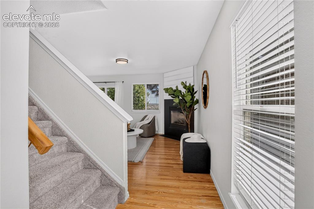 Image 8 of 35: View from front door entry into living room with natural oak flooring.