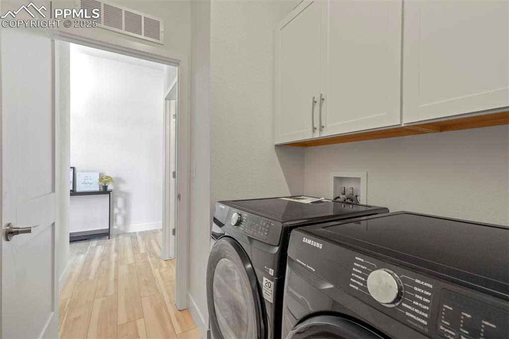 Image 13 of 45: Laundry room featuring light wood-type flooring, independent washer and dry
