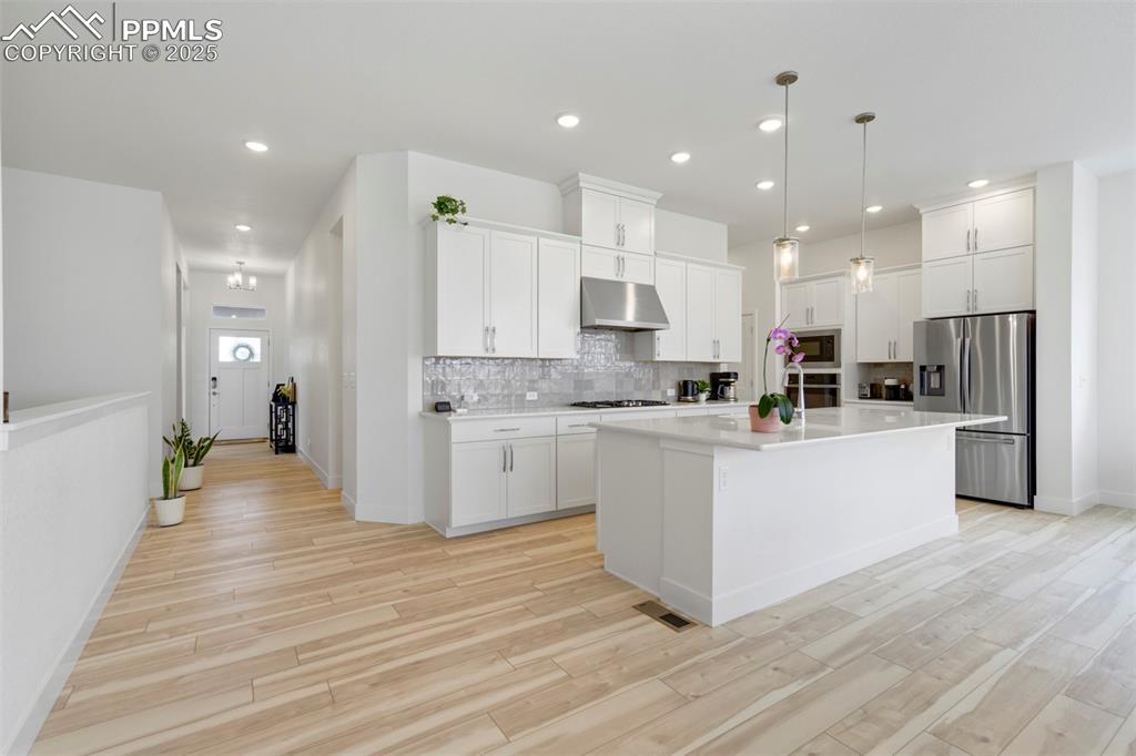 Image 16 of 45: Kitchen with tasteful backsplash, appliances with stainless steel finishes,