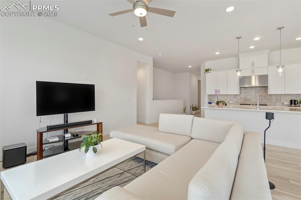 Image 17 of 45: Living area with light wood-style flooring, recessed lighting, and a ceilin