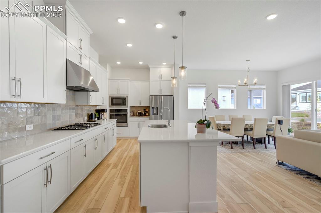 Image 19 of 45: Kitchen with recessed lighting, white cabinetry, stainless steel appliances