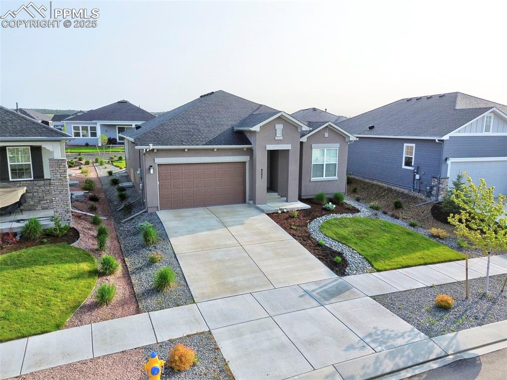 Image 2 of 45: Ranch-style house with stucco siding, driveway, a garage, a shingled roof, 