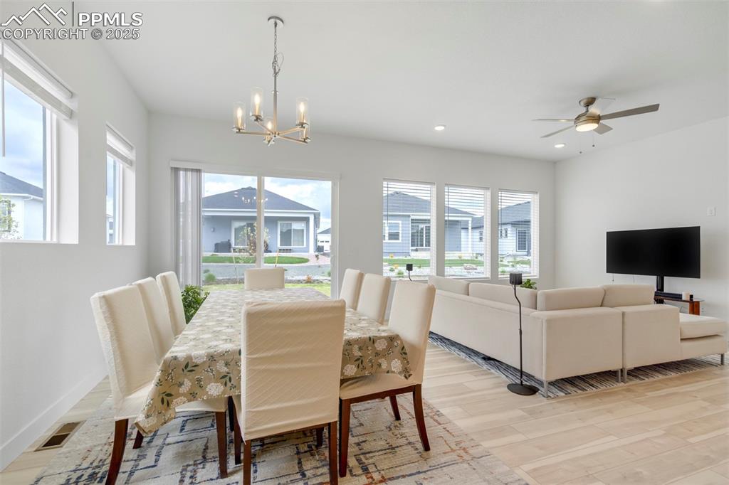 Image 23 of 45: Dining space with light wood-style floors, a chandelier, recessed lighting,
