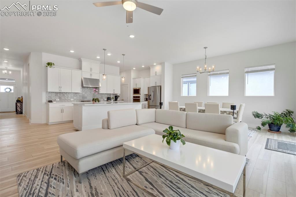 Image 24 of 45: Living area featuring a chandelier, recessed lighting, light wood-style flo