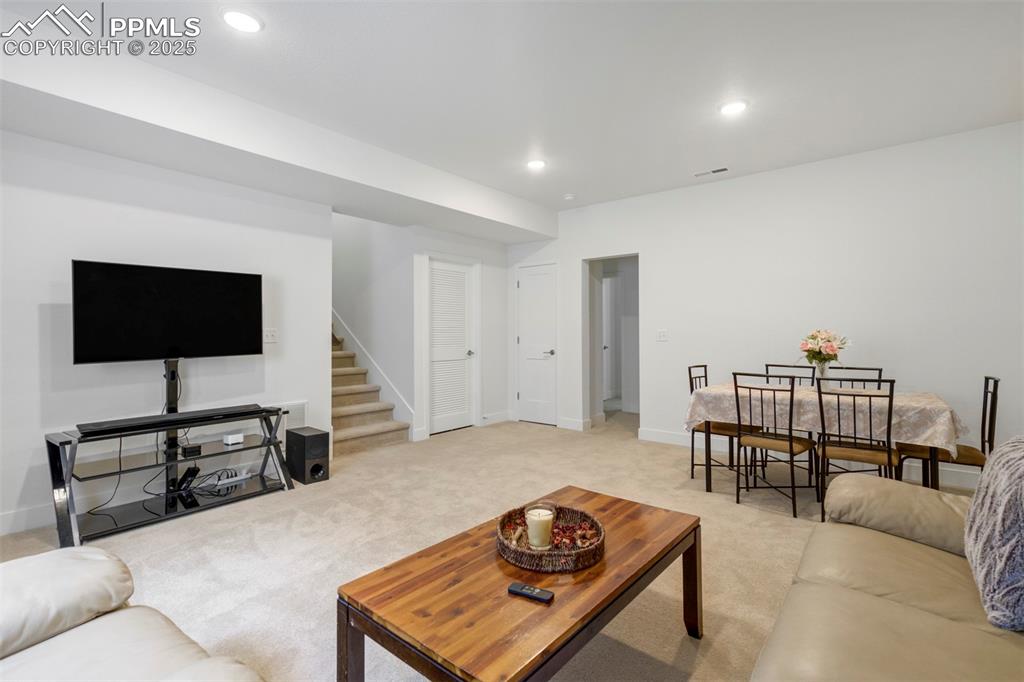 Image 35 of 45: Carpeted living room featuring stairs and recessed lighting