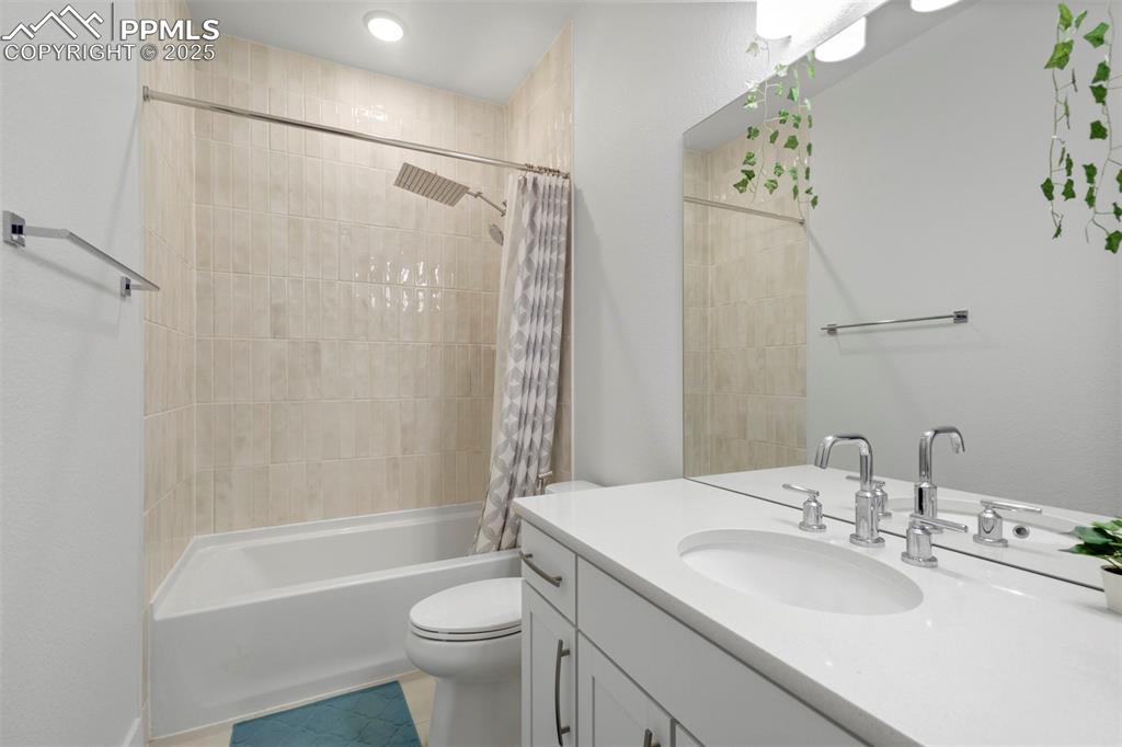 Image 37 of 45: Full bath featuring shower / bath combination with curtain, vanity, and lig