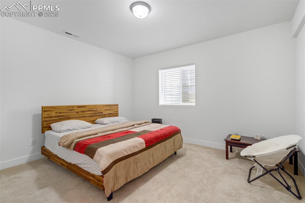 Image 39 of 45: Bedroom with carpet floors and baseboards