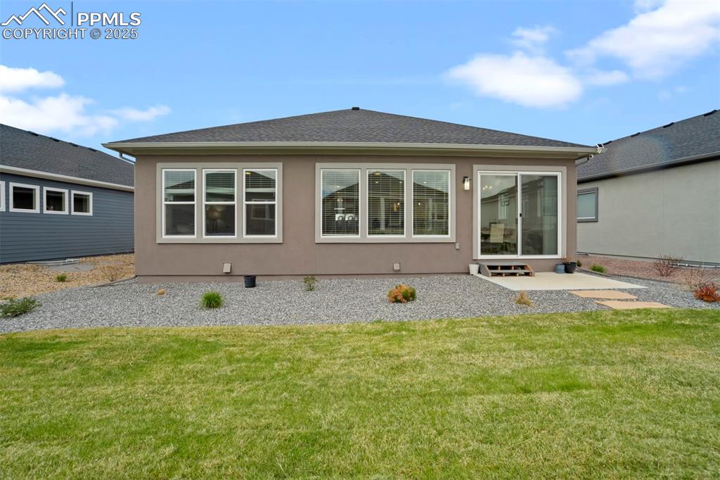 Image 43 of 45: Rear view of property featuring a lawn, a patio area, stucco siding, and a 