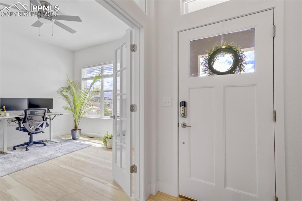 Image 8 of 45: Entryway with light wood-style floors and a ceiling fan