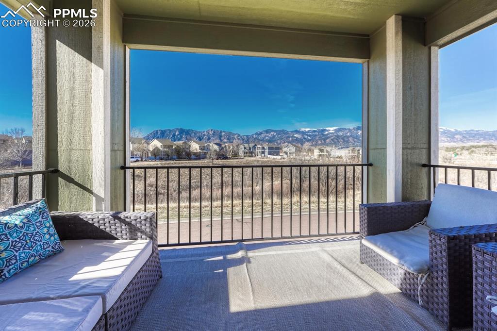 Image 19 of 50: Balcony overlooks green space and mountain views