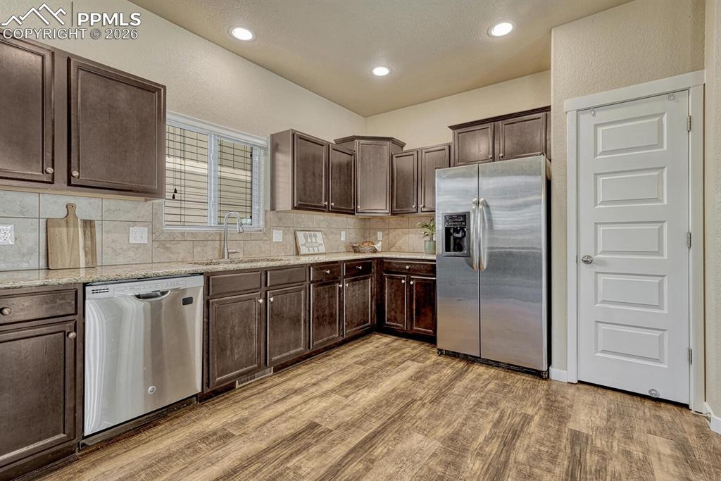 Image 9 of 50: Kitchen features granite counters, stainless steel appliances, and pantry
